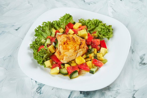 Portion of fresh and healthy salad with warm baked chicken. Balanced food.