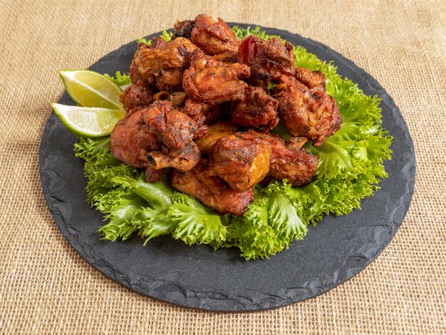 Portion of fried chicken on black stone plate