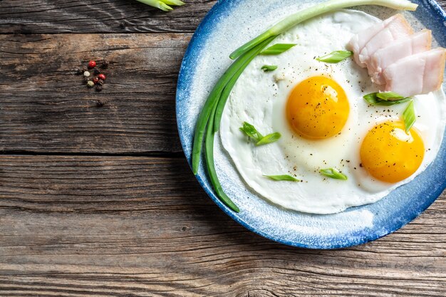 Photo portion of fried eggs with lard bacon