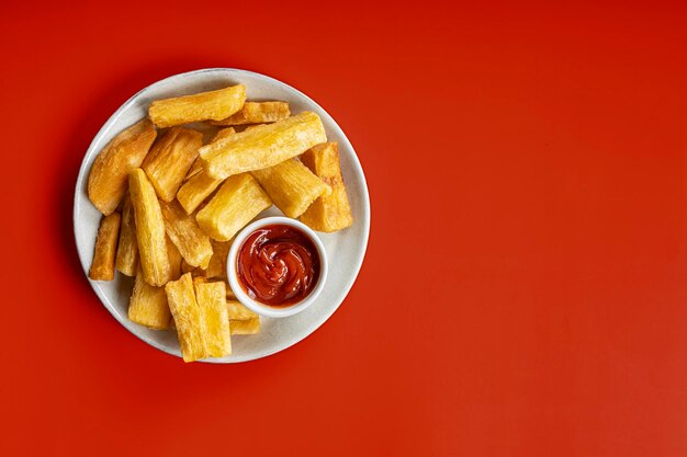 Photo a portion of fried maniocs mandiocas on a on a red background traditional brazilian food