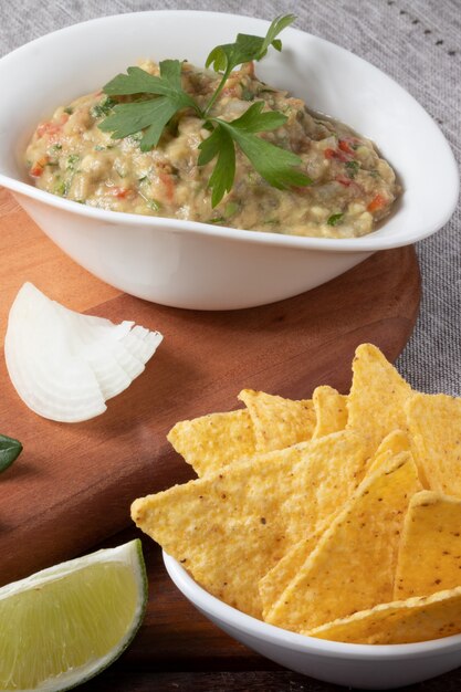 Portion of guacamole in a bowl with nacho.