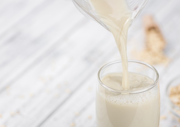 Portion of healthy Oat Milk on an old wooden table selective focus closeup shot