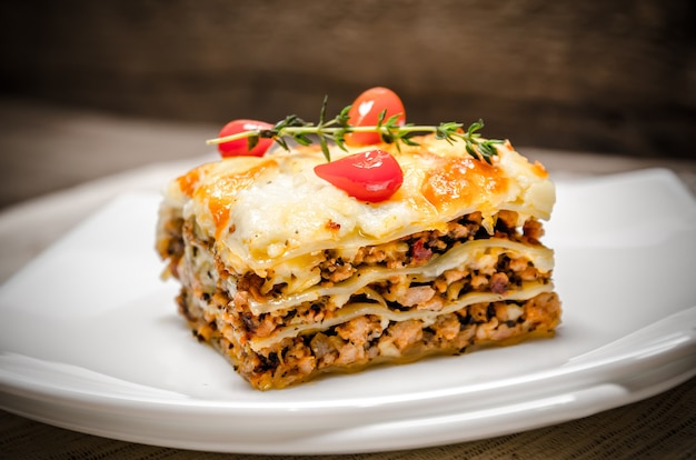 Portion of lasagna on the wooden table