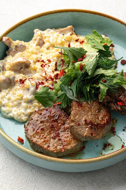 Photo portion of medallions and garnish with mushrooms