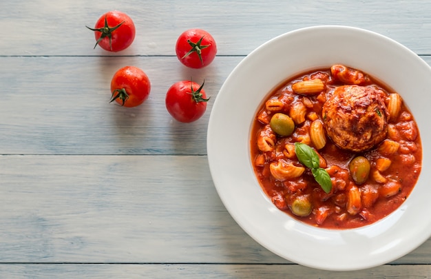 Portion of minestrone soup with meatball