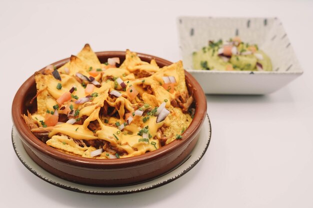 A portion of nachos with cheese and guacamole