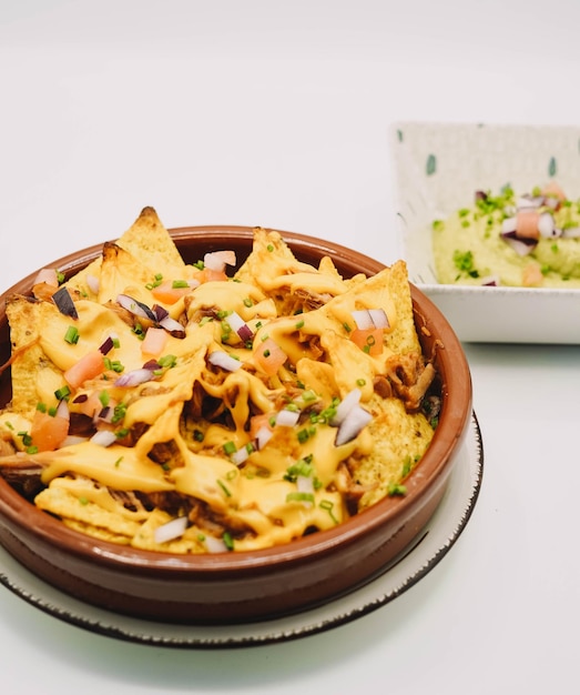 A portion of nachos with cheese and guacamole