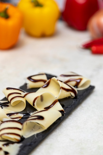 Porzione di parmigiano a scaglie con aceto balsamico in pietra nera