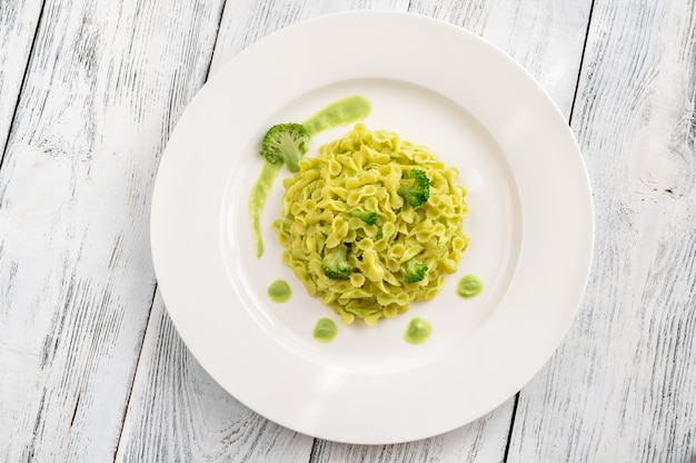 Portion of pasta with broccoli on white plate