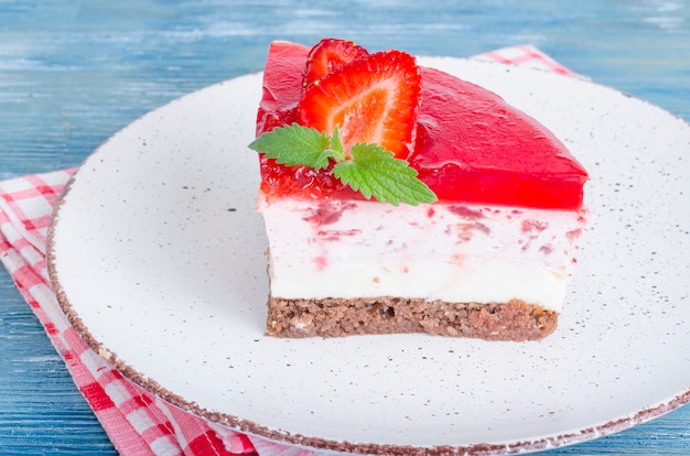 Portion piece of cottage cheese cheesecake with fresh strawberries and strawberry jelly