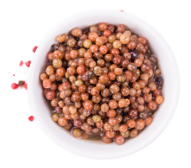 Portion of preserved Pink Peppercorns isolated on white