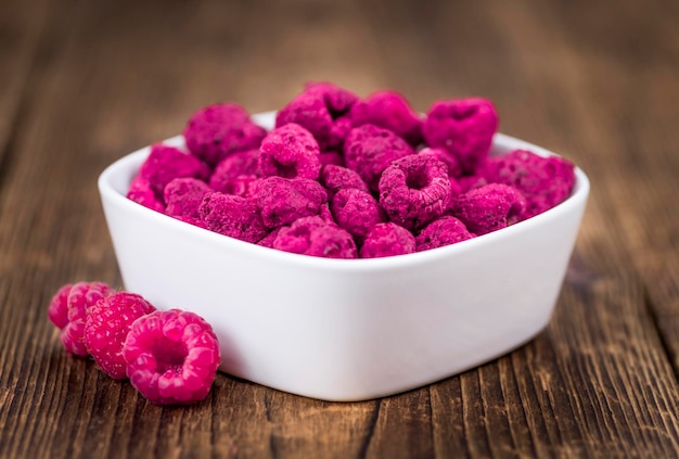 Portion of Raspberries dried on wooden background selective focus