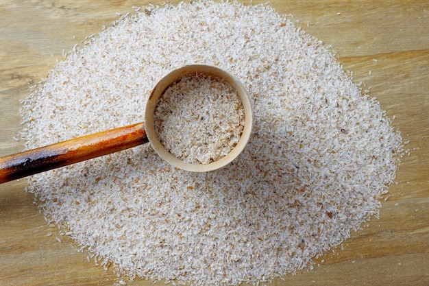 Portion of raw psyllium husk over rustic wooden table top view