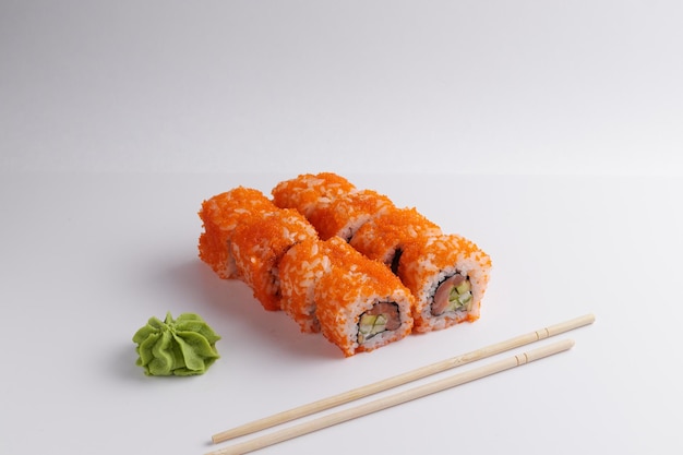 A portion of rolls on a stand, japanese food, sushi on the table, chinese chopsticks, light background