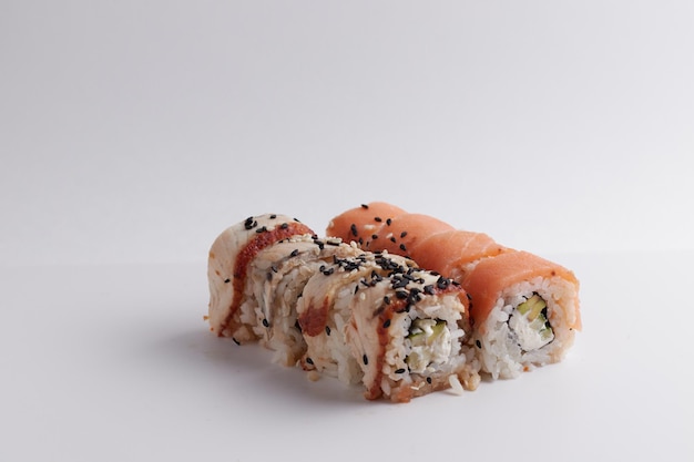 A portion of rolls on a stand, japanese food, sushi on the table, chinese chopsticks, light background