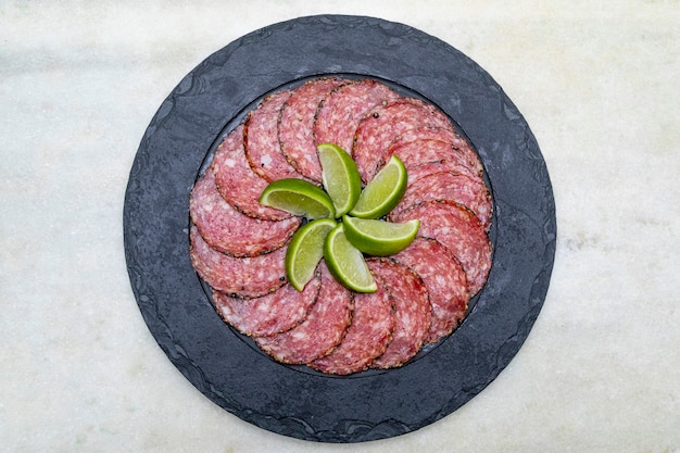 Portion of salami on black stone plate