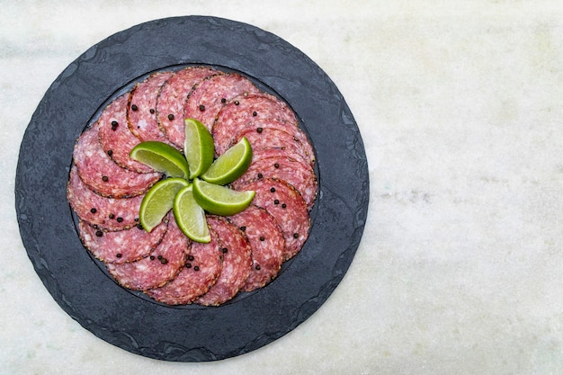 Portion of salami on black stone plate