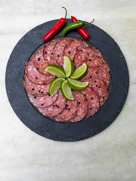 Portion of salami on black stone plate