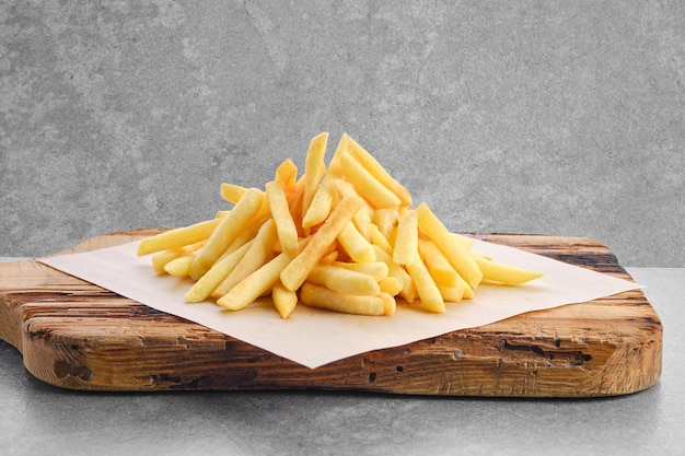 Portion of salty french fries on paper