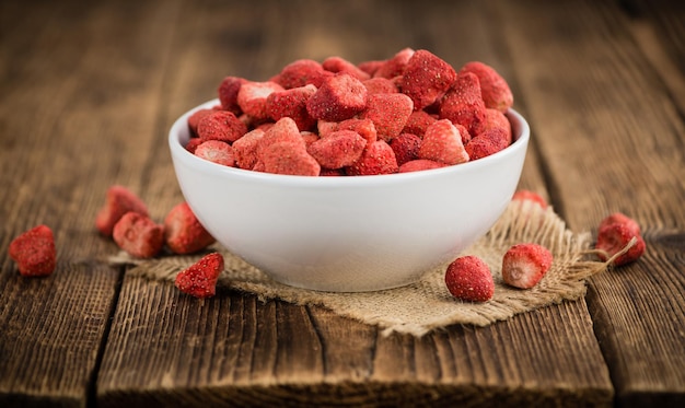 Portion of Strawberries dried on wooden background selective focus