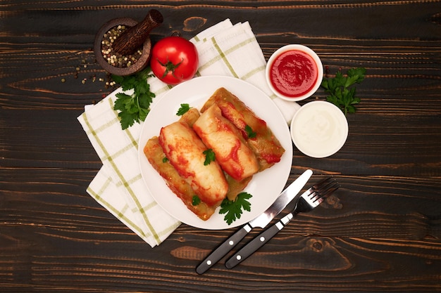 Portion of stuffed cabbage rolls on wooden table