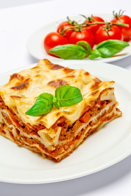 Portion of tasty lasagna isolated on white