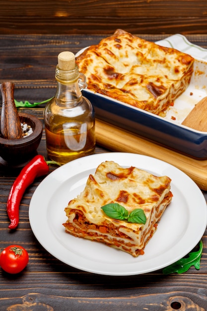 Portion of tasty lasagna on wooden backgound