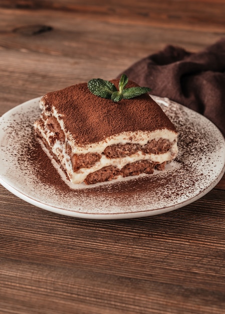 Portion of tiramisu italian dessert on wooden background