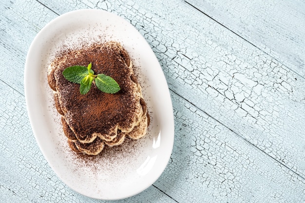 Porzione di tiramisù sul piatto da portata bianco