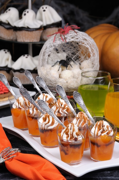 Photo portioned dessert of pumpkin with whipped cream and chocolate topping on halloween