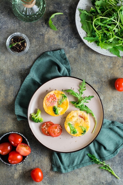 Portioned omelet from eggs broccoli and tomatoes on a plate Homemade breakfast Top and vertical