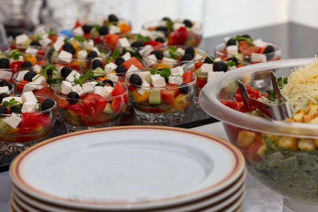 Portioned salads and empty plates on the buffet table Beautiful serving Closeup