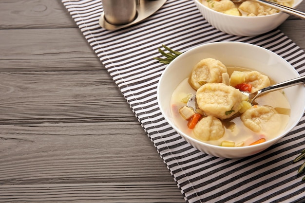 Portions of delicious chicken and dumplings on dining table