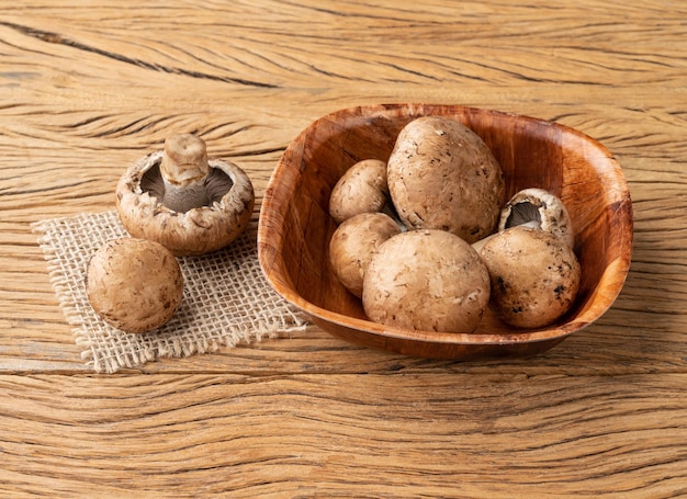 Portobello mushrooms in a bowl over wooden table