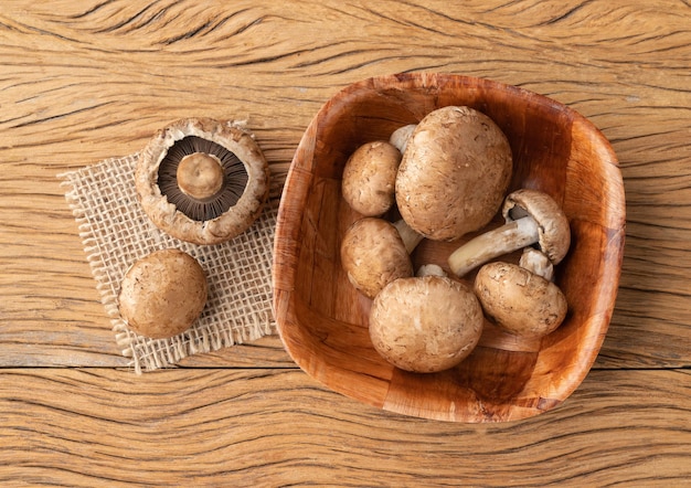 Portobello mushrooms in a bowl over wooden table