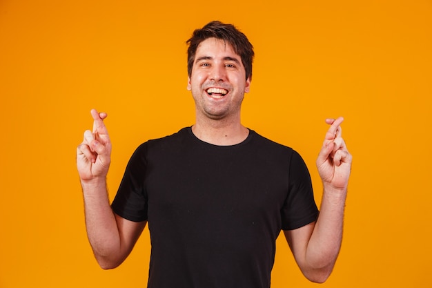 A portrair of a young man with crossed fingers