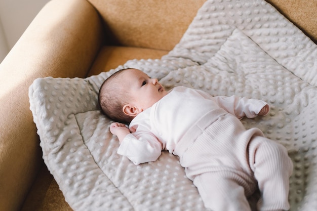 Portrait of a 1 month old baby Cute newborn baby lying on a developing rug Love baby Newborn baby and mother