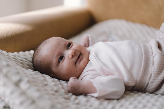 Portrait of a 1 month old baby Cute newborn baby lying on a developing rug Love baby Newborn baby and mother