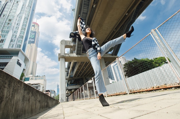 Portrait of 20s Asian Woman brown hair wear jacket high fashion make up under blue sky cloud. Beautiful female express feeling emotion smile happy over train track railroad station