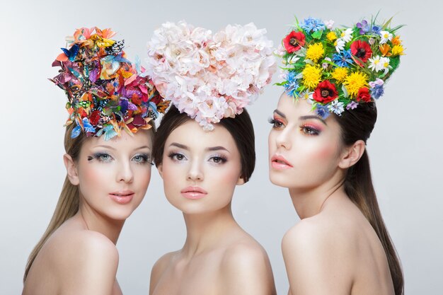 Portrait of 3 young girls posing with wreaths of flowers