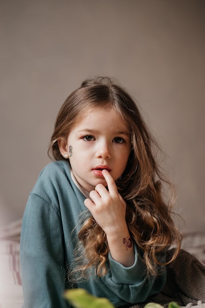 朝の光で写真のポーズをとって新鮮なピンクのチューリップの花束を保持している4歳の少女の肖像画