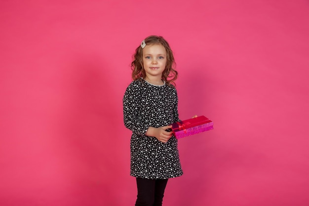 Portrait 5-6 year old girl in dress on pink isolated