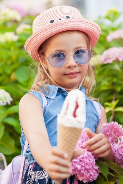 Ritratto di una bambina di 7 anni che mangia un gelato gustoso.