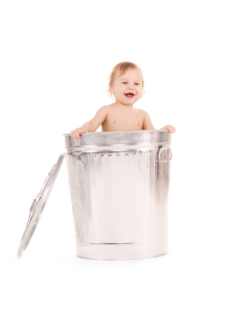 Photo portrait of adorable baby in trash can