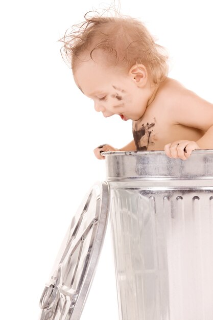 Portrait of adorable baby in trash can