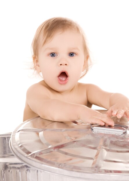 Portrait of adorable baby in trash can