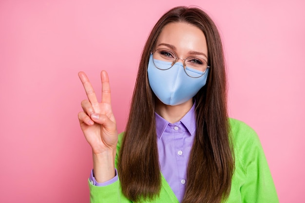 Photo portrait of adorable charming youth girl  make v-sign wear respiratory mask isolated over pastel color background