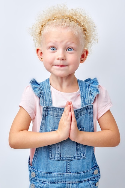 Foto ritratto di adorabile e carina ragazza dai capelli biondi bambino felice adorabile tenere le mani insieme