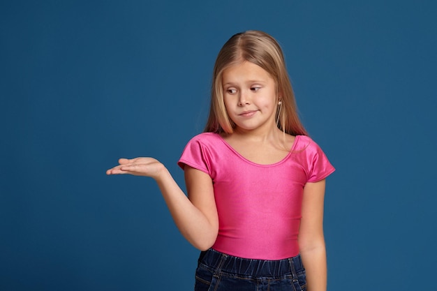 Foto ritratto di adorabile bambina emotiva su sfondo blu