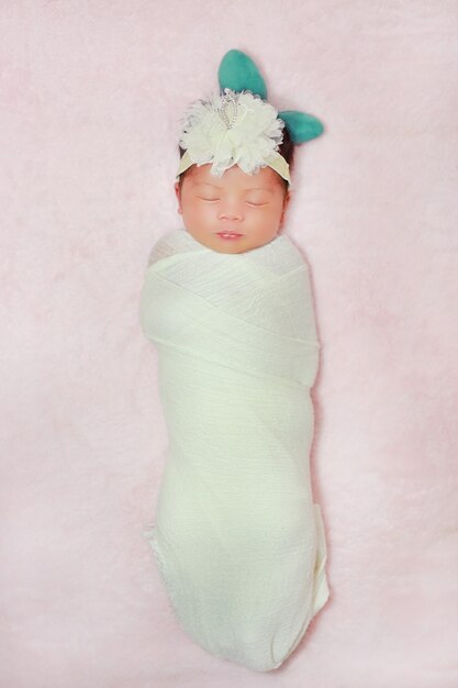 Portrait adorable of little asian newborn baby sleeping on fluffy soft bed